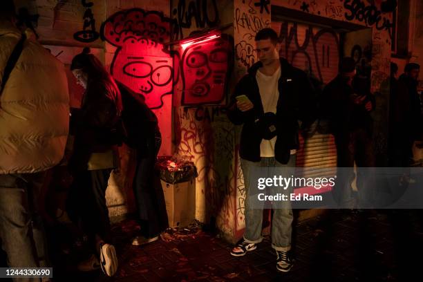 People stand outside a bar after a Halloween party ended before the start of a city wide 11pm curfew on October 29, 2022 in Kyiv, Ukraine. In recent...