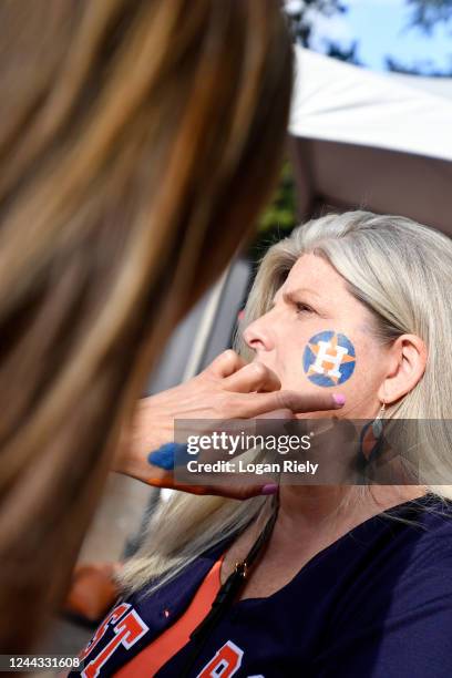 Houston Astros fan receives face art of the teams logo outside the stadium before Game 2 of the 2022 World Series between the Philadelphia Phillies...