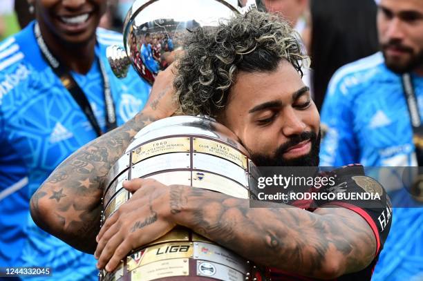 Flamengo's Brazilian forward Gabriel Barbosa embraces the trophy after winning the Copa Libertadores final, after the football match between...