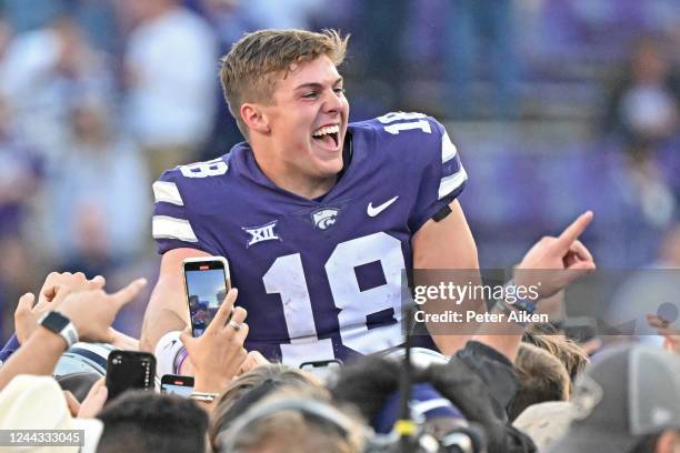 Quarterback Will Howard of the Kansas State Wildcats celebrates as he is carried across the field after beating the Oklahoma State Cowboys at Bill...