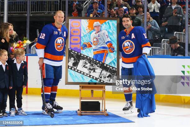 Cal Clutterbuck poses for a photo with Josh Bailey of the New York Islanders in honor of his 1,000 NHL game played during a pregame ceremony at UBS...