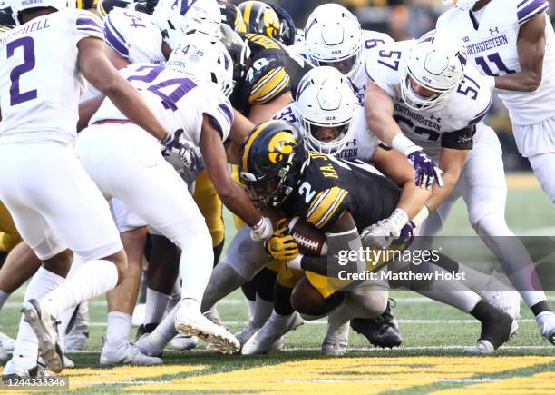 Running back Kaleb Johnson of the Iowa Hawkeyes is tackled during the second half by linebacker Bryce Gallagher of the Northwestern Wildcats at...