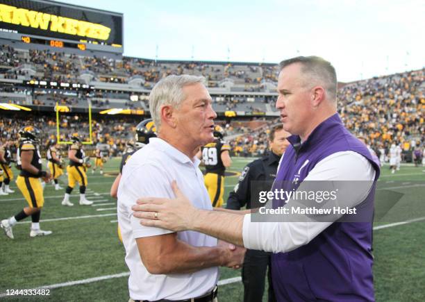 Head coach Pat Fitzgerald of the Northwestern Wildcats shakes hands with head coach Kirk Ferentz of the Iowa Hawkeyes following their match-up at...