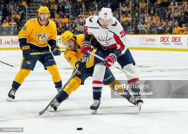 Dante Fabbro of the Nashville Predators battles for the puck against Anthony Mantha of the Washington Capitals during an NHL game at Bridgestone...