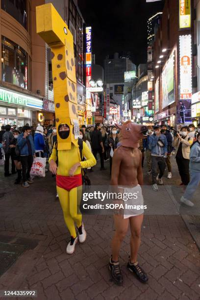 Men seen wearing a giraffe and a horse costume in the street as people enjoy Halloween in Shibuya Centre Gai. After several years of Coronavirus and...