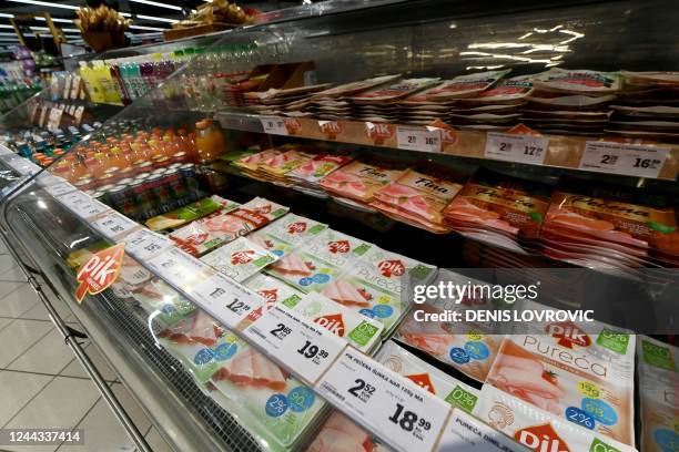 This photograph taken on September 26 shows food items on a supermaket shelf displaying product prices in both Kuna and Euro currency, in Zagreb. -...