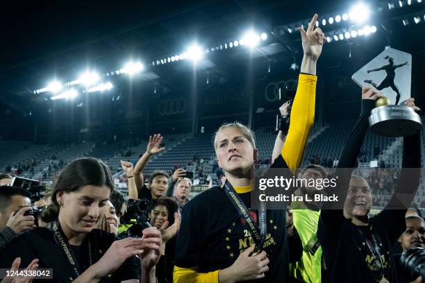 Bella Bixby of Portland Thorns FC and Kelli Hubly of Portland Thorns FC hold up the Championship Trophy after winning the 2022 National Womens Soccer...