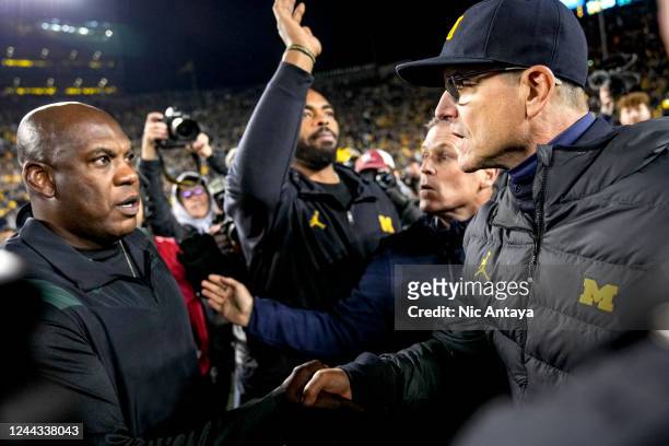 Head coach Jim Harbaugh of the Michigan Wolverines shakes hands with head coach Mel Tucker of the Michigan State Spartans at Michigan Stadium on...