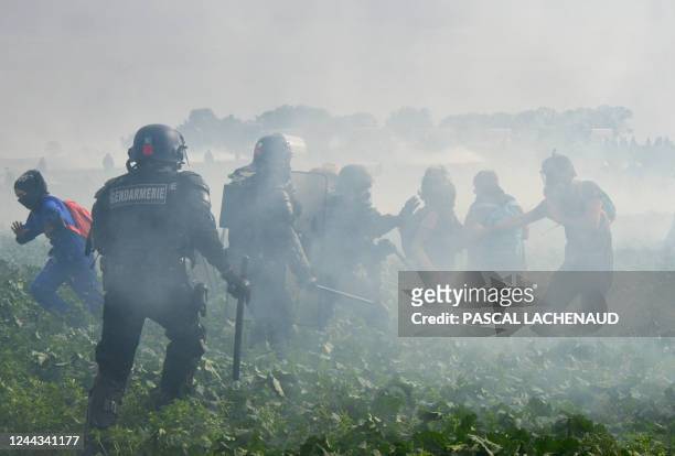 Activists clash with French riot mobile gendarmes among tear gas during a demonstration called by the collective "Bassines Non Merci" against the...