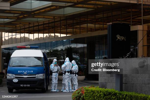 Police officers wearing personal protective guard the entrance of MGM Cotai casino resort, developed by MGM China Holdings Ltd., placed under...