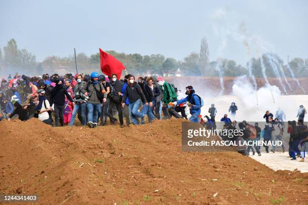 Activists clash with riot mobile gendarmes among tear gas during a demonstration called by the collective "Bassines Non Merci" against the "basins"...