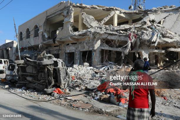 Local residents looks at debris from a destroyed buildings in Mogadishu on October 30, 2022 after an car bombing targeted the education ministry on...
