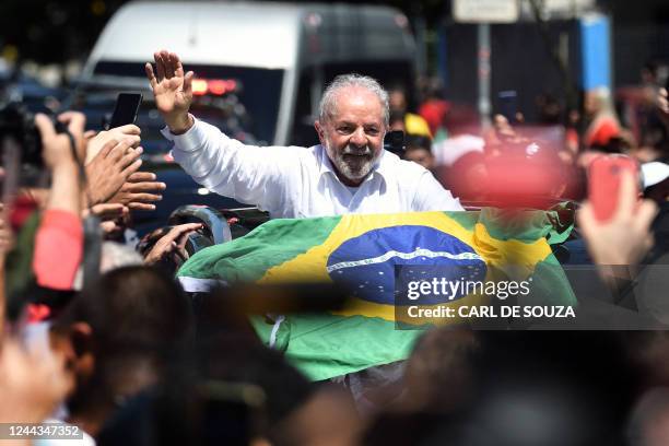 Brazilian former President and candidate for the leftist Workers Party Luiz Inacio Lula da Silva waves at supporters while leaving the polling...