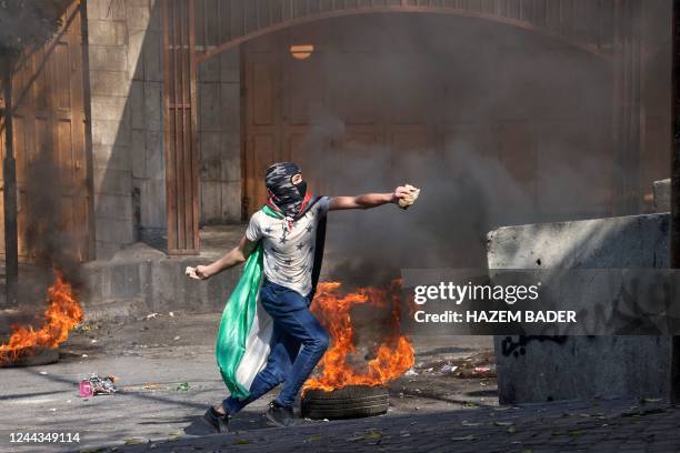 Palestinian protesters hurl rocks amid clashes with Israeli security forces in the city center of Hebron in the occupied West Bank, on October 30,...