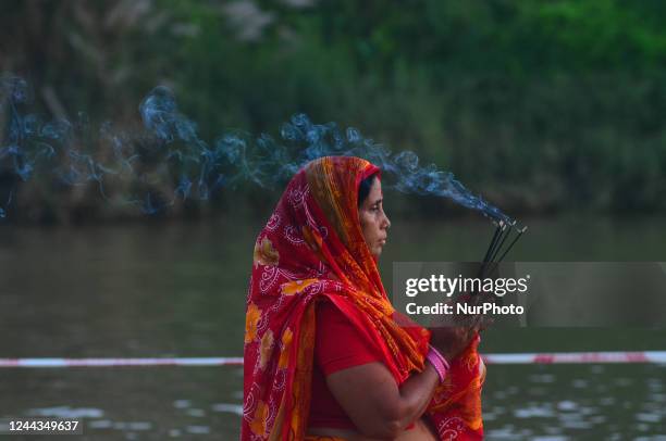 An Indian Hindu devotee holds incense sticks in his hand to offers prayers to Sun God during the Chhath Puja in Dimapur, India north eastern state of...