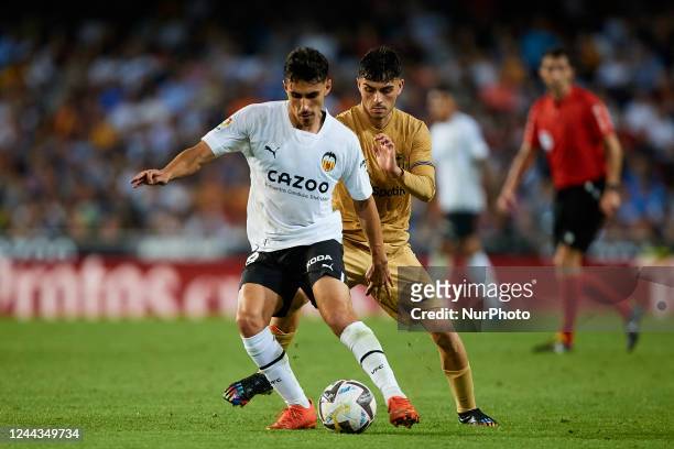 Andre Almeida of Valencia CF competes for the ball with Pedri of FC Barcelona during the LaLiga Santander match between Valencia CF and FC Barcelona...
