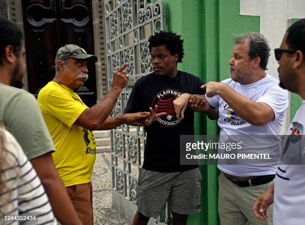 Supporters of Brazilian President and re-election candidate Jair Bolsonaro hold and shout at a supporter of Brazilian former President and candidate...