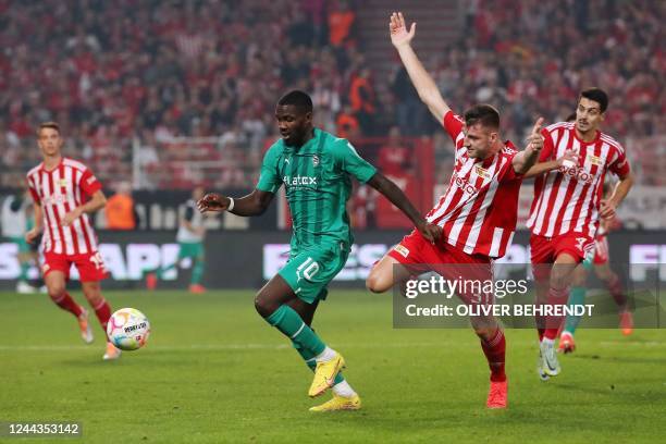 Moenchengladbach's French forward Marcus Thuram and Union Berlin's German defender Robin Knoche vie for the ball during the German first division...