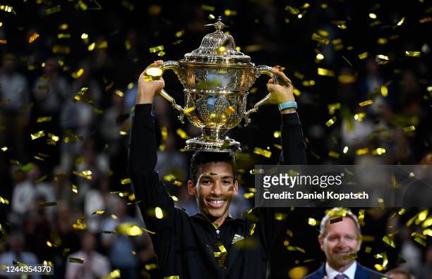 Felix Auger-Aliassime of Canada lifts the trophy after his final match against Holger Rune of Denmark during day nine of the Swiss Indoor Basel at...