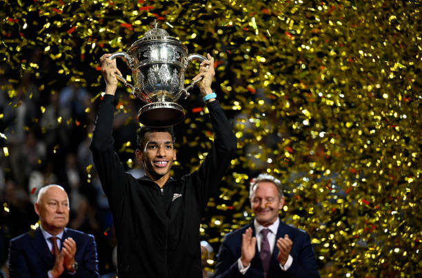 Felix Auger-Aliassime of Canada lifts the trophy after his final match against Holger Rune of Denmark during day nine of the Swiss Indoor Basel at...