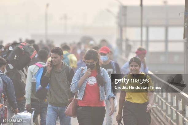 Commuters in Anand Vihar walk through a dense blanket of smog in the early hours of Sunday amid deteriorating air quality levels, on October 30, 2022...