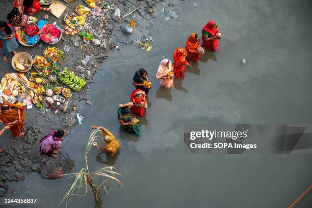 Top view of devotees standing in Yamuna river and offering prayers to Sun God at Kalindi Kunj Barrage, Noida. Chhath puja is dedicated to the sun god...