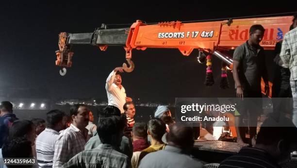 Rescuers work at night after a cable bridge across the Machchu river collapsed in Morbi district, western Gujarat state, in India on 30, 2022. Dozens...