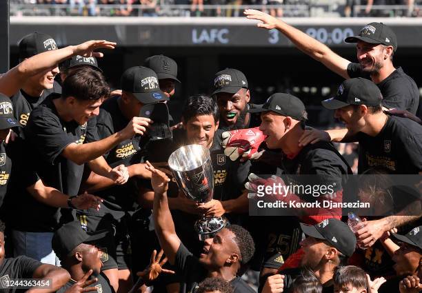 Carlos Vela of Los Angeles FC holds the championship trophy as he celebrates with teammates after defeating Austin FC, 3-0, during the Western...