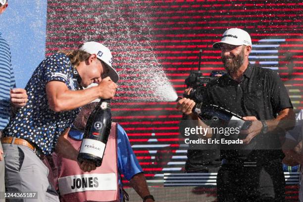 Team Captain Dustin Johnson of 4 Aces GC sprays champagne on Team Captain Cameron Smith of Punch GC on the podium after the team championship...