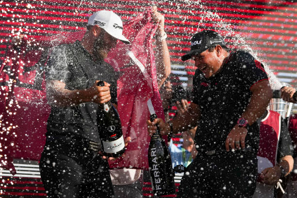 Team Captain Dustin Johnson of 4 Aces GC and Patrick Reed celebrate on the podium after the team championship stroke-play round of the LIV Golf...