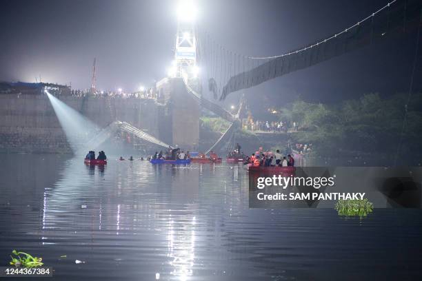 Indian rescue personnel conduct search operations after a bridge across the river Machchhu collapsed in Morbi, some 220 kms from Ahmedabad, early on...