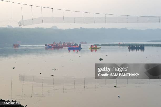 Rescue personnel conduct search operations after a bridge across the river Machchhu collapsed at Morbi in India's Gujarat state on October 31, 2022....