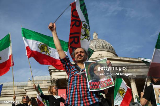 Iranians protesters hold flags of Iran as they continue to call for justice for Mahsa Amini who died in a hospital in Tehran, Iran, during her...