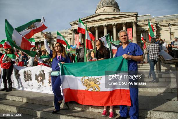 Iranians protesters hold flags of Iran as they continue to call for justice for Mahsa Amini who died in a hospital in Tehran, Iran, during her...