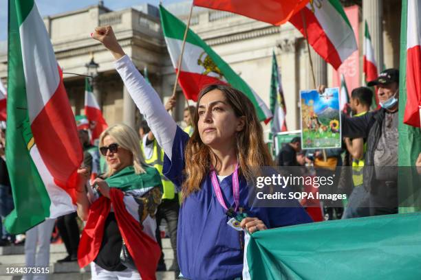 Iranians protesters hold flags of Iran as they continue to call for justice for Mahsa Amini who died in a hospital in Tehran, Iran, during her...