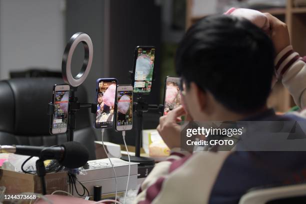 An employee of Nantong Bolia Rain Gear Manufacturing Company in the logistics park sells electric hot water bottles via live streaming in Nantong,...