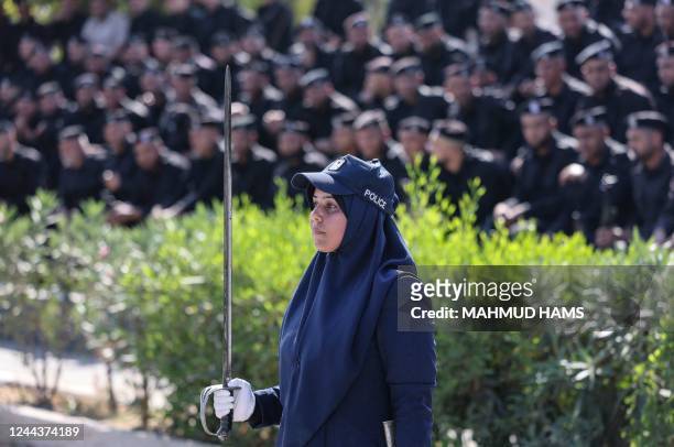 Female member of the Hamas security forces is pictured in front of male comrades during a graduation ceremony held by the "Islamic Resistance...