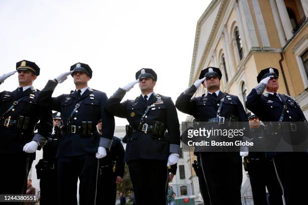 Boston, MA Members of the Worcester Police Department salute during the playing of the National Anthem at the Massachusetts Law Enforcement Memorial...