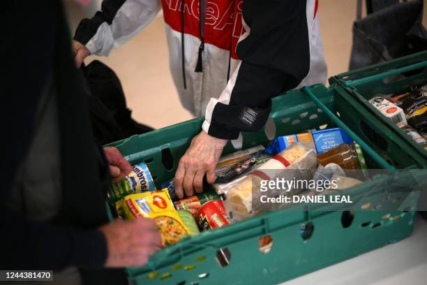 Member the public looks through food items inside a foodbank in Hackney, north-east London on October 31, 2022. - There were dozens of people on...