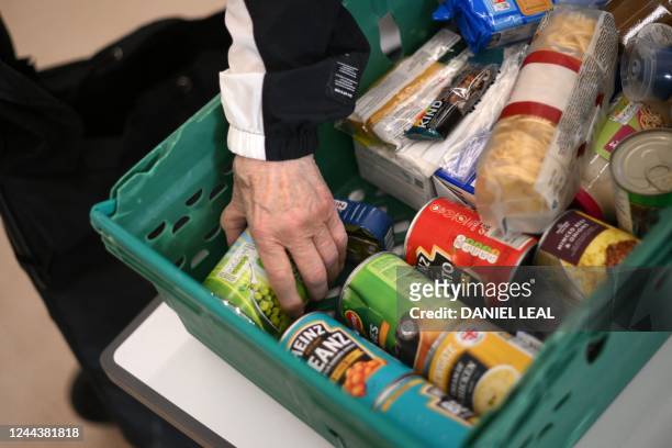 Member the public looks through food items inside a foodbank in Hackney, north-east London on October 31, 2022. - There were dozens of people on...