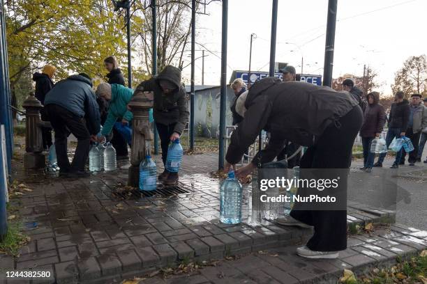 People take water from a water pump after about 80 percent residents of Kyiv were left without water supply after a Russian missile attack on...