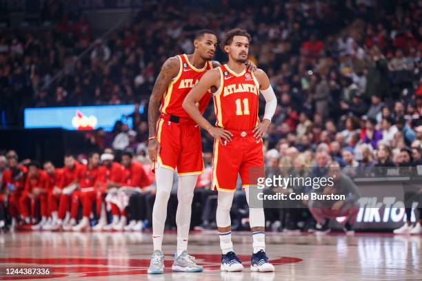 Dejounte Murray and Trae Young of the Atlanta Hawks talk between plays against the Toronto Raptors at Scotiabank Arena on October 31, 2022 in...