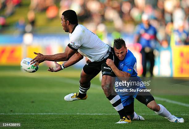 Naipolioni Nalaga of Fiji offloads as he is tackled by Llewellyn Winkler of Namibia during the IRB 2011 Rugby World Cup Pool D match between Fiji and...