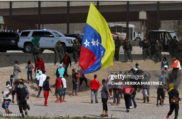 Venezuelan migrants demonstrate while others flee from US Border Patrol agents of the El Paso sector during a protest against US immigration policies...