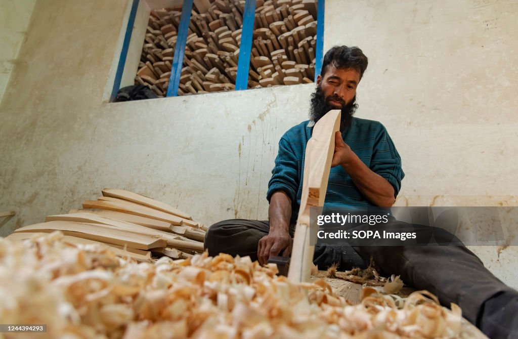 Bat Making A worker checks a shape of a produced cricket bat made from Kashmiri ...
