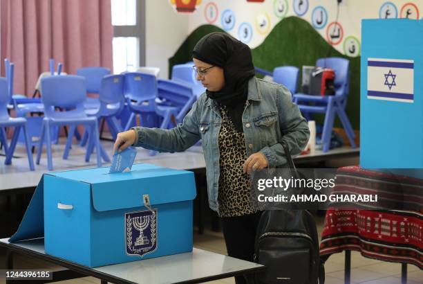 An Arab-Israeli woman voter casts her ballot at a polling station in the predominantly-Arab city of Taybeh in central Israel during the national...