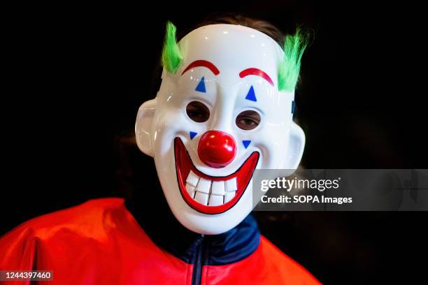 Young man is wearing a clown mask during a Halloween party in Gdansk.