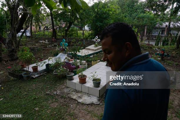 Salvadoran looks at the graves of his relatives buried in the backyard of their house, within the framework of the Day of the Dead, in the...