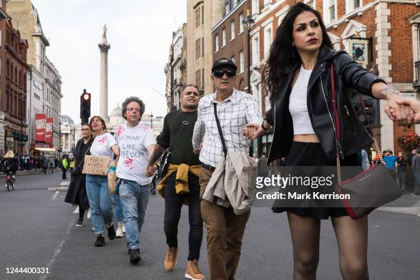 Demonstrators form a human chain as they march in solidarity with protesters across Iran on 29 October 2022 in London, United Kingdom. Similar human...
