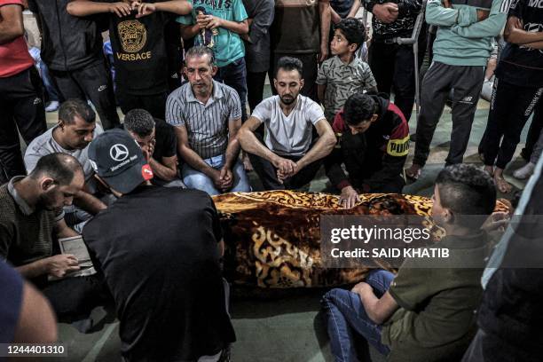 Mourners gather to read from the Koran, Islam's holy book, around one of the bodies of two Palestinian migrants who died at sea, upon their...